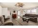 Inviting living area featuring laminate flooring, ceiling fan, and an open layout flowing into the kitchen at 48773 Cerezo Rd # 20, Maricopa, AZ 85139