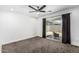 Bright bedroom featuring a ceiling fan, carpeted floors, and a sliding glass door to backyard at 5709 S 13Th Ave, Phoenix, AZ 85041
