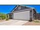 Charming home featuring a white garage door, gray siding, and stone accents, enhancing curb appeal at 5709 S 13Th Ave, Phoenix, AZ 85041