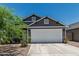 Charming home with gray siding, a white garage door, and well-maintained landscaping, creating a welcoming ambiance at 5709 S 13Th Ave, Phoenix, AZ 85041