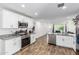 Open-concept kitchen features granite counters, stainless appliances, and wood-look floors at 5709 S 13Th Ave, Phoenix, AZ 85041
