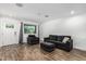 Cozy living room featuring wood-look floors, sofa, chair and large window at 5709 S 13Th Ave, Phoenix, AZ 85041