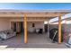 A covered back patio area featuring a table and chairs, and an outdoor sofa with wood support posts at 5807 W Encanto Blvd, Phoenix, AZ 85035