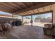 A covered back patio area featuring a table and chairs, outdoor sofa, and block wall backyard at 5807 W Encanto Blvd, Phoenix, AZ 85035