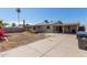 A large backyard featuring a concrete driveway and a covered patio area at 5807 W Encanto Blvd, Phoenix, AZ 85035
