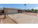Spacious driveway leading to a one-story home with a garage and minimalist landscaping at 5807 W Encanto Blvd, Phoenix, AZ 85035