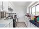Functional kitchen features white cabinets, tile floors, and abundant natural light from a window over the sink at 5807 W Encanto Blvd, Phoenix, AZ 85035