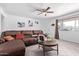 Inviting living room featuring a comfortable leather sectional and a cozy ceiling fan at 5807 W Encanto Blvd, Phoenix, AZ 85035