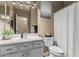 Cozy bathroom featuring a bright white vanity, toilet, and shower with curtain, well-lit by vanity lighting at 609 S 122Nd Dr, Avondale, AZ 85323