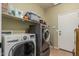 Functional laundry room with modern front-load washer and dryer, complemented by shelving for storage solutions at 609 S 122Nd Dr, Avondale, AZ 85323