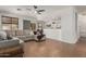 Open-concept living room with tile floors, a ceiling fan, and a sectional couch, open to the dining area at 609 S 122Nd Dr, Avondale, AZ 85323