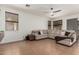 Spacious living room featuring tile flooring, ceiling fan, large sectional couch, and bright natural light at 609 S 122Nd Dr, Avondale, AZ 85323