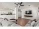 Comfortable living room featuring tile flooring, large sectional, and mounted television, flowing into kitchen at 609 S 122Nd Dr, Avondale, AZ 85323