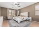 Comfortable main bedroom with a ceiling fan, carpet, a large window, and an upholstered headboard at 609 S 122Nd Dr, Avondale, AZ 85323