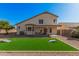 Spacious backyard featuring a covered patio and artificial turf, perfect for outdoor entertaining at 640 W Country Estates Ave, Gilbert, AZ 85233