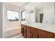 Bathroom features a double sink vanity, bathtub, and a window with neighborhood views at 640 W Country Estates Ave, Gilbert, AZ 85233