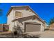 Charming two-story home featuring a tan stucco exterior, two-car garage, and low-maintenance desert landscaping at 640 W Country Estates Ave, Gilbert, AZ 85233