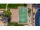 Aerial view of a basketball court and sand volleyball court, surrounded by well-maintained lawns and desert vegetation at 6936 E Snowdon St, Mesa, AZ 85207