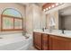 Bathroom with a soaking tub, double vanity and wood-look cabinets at 6936 E Snowdon St, Mesa, AZ 85207