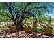 Charming courtyard with iron archway and lush greenery at 6936 E Snowdon St, Mesa, AZ 85207
