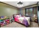 Bedroom with a comfortable bed, window with wood shutters, and organized toy storage at 7725 W Dreyfus Dr, Peoria, AZ 85381