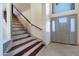Bright foyer with tile flooring, a staircase, and a large front door with glass accents at 7725 W Dreyfus Dr, Peoria, AZ 85381