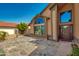 Elegant front entrance with a stone walkway, tall windows, and a view of the home's mature landscaping at 7725 W Dreyfus Dr, Peoria, AZ 85381