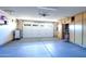 Spacious garage with epoxy flooring, an insulated door, and built-in cabinets for ample storage space at 7725 W Dreyfus Dr, Peoria, AZ 85381