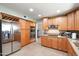 Modern kitchen featuring stainless steel refrigerator, double ovens, and beautiful wood cabinetry at 7725 W Dreyfus Dr, Peoria, AZ 85381