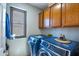 Functional laundry room equipped with large washer and dryer, plus storage cabinets at 7725 W Dreyfus Dr, Peoria, AZ 85381
