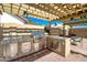 Outdoor kitchen under pergola features a sink, grill, drawers, and cabinets, designed for outdoor cooking at 7725 W Dreyfus Dr, Peoria, AZ 85381