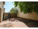 This backyard features a decorative brick paver area, mature landscaping, and a gated entrance to an alleyway at 813 E Agua Fria Ln, Avondale, AZ 85323