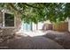 This backyard features brick pavers, mature landscaping, and a covered patio off of the home's sliding glass door at 813 E Agua Fria Ln, Avondale, AZ 85323