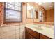 Classic bathroom with neutral tile, single sink vanity, and patterned wallpaper at 813 E Agua Fria Ln, Avondale, AZ 85323