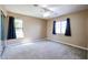 Bright bedroom featuring two windows, ceiling fan and neutral carpeting at 813 E Agua Fria Ln, Avondale, AZ 85323