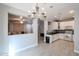 Open-concept kitchen with stainless steel appliances, white cabinetry, and wood-look flooring at 813 E Agua Fria Ln, Avondale, AZ 85323