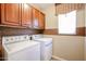 Functional laundry room featuring washer, dryer, and overhead cabinets at 813 E Agua Fria Ln, Avondale, AZ 85323