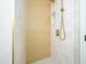 Custom tile shower features gold fixtures, a shower niche, and a light wooden accent wall at 8341 E Keim Dr, Scottsdale, AZ 85250