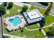Aerial shot of the community pool featuring lounge chairs, umbrellas, a clubhouse, manicured lawns, and mature landscaping at 8341 E Keim Dr, Scottsdale, AZ 85250