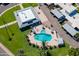 Aerial view of the community pool featuring lounge chairs, umbrellas, mature landscaping, and a clubhouse at 8341 E Keim Dr, Scottsdale, AZ 85250