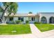 A well-kept front yard with lush grass and mature trees enhances the curb appeal of this inviting single-story home at 8341 E Keim Dr, Scottsdale, AZ 85250