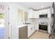 Updated kitchen features stainless appliances, white cabinets, white countertops, and a view to the backyard at 8341 E Keim Dr, Scottsdale, AZ 85250
