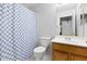 Bathroom featuring a wood vanity, toilet, and blue shower curtain at 878 E Mountain View Rd, San Tan Valley, AZ 85143