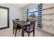 Inviting dining area with a dark wood table, and minimalist wooden shelving at 878 E Mountain View Rd, San Tan Valley, AZ 85143