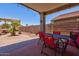 Covered patio features a dining set, string lights, and a desert landscaped backyard at 878 E Mountain View Rd, San Tan Valley, AZ 85143