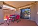 Covered patio features dining set, sliding door, and a desert landscaped backyard at 878 E Mountain View Rd, San Tan Valley, AZ 85143