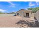 Gravel backyard with covered patio, exterior door, and privacy walls at 9261 W Sheridan St, Phoenix, AZ 85037