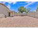Spacious gravel backyard with covered patio and exterior back door at 9261 W Sheridan St, Phoenix, AZ 85037