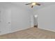 Bedroom with ceiling fan, neutral carpet, and a large walk-in closet at 9261 W Sheridan St, Phoenix, AZ 85037