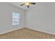 Bedroom with neutral carpet, ceiling fan, and a large window at 9261 W Sheridan St, Phoenix, AZ 85037